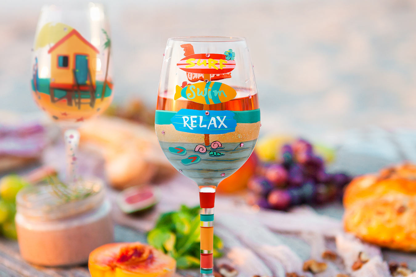 Colorful wine glass with 'Relax' text on a table with food