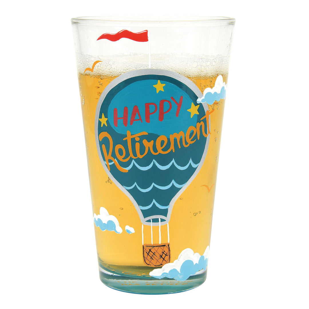 A hand painted beer glass with a 'Happy Retirement' theme, featuring a hot air balloon design, clouds, and decorative elements.