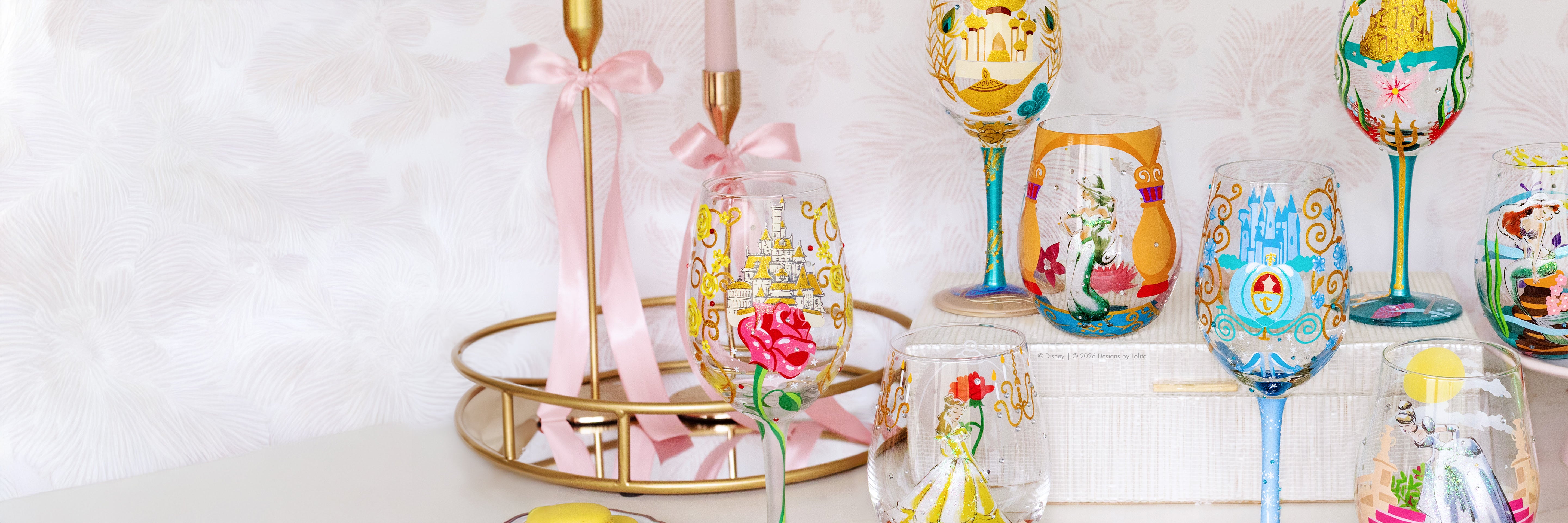 Colorful hand-painted glasses on a white surface with a gold stand.